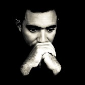 14745376-dramatic-black-and-white-face-of-a-worried-young-man-emerging-from-a-black-background